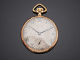 an antique pocket watch on a black surface with a black background