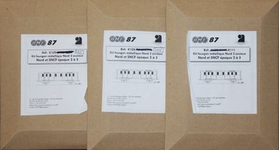trois boîtes contenant du matériel électronique posées sur une table en bois