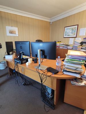 a desk with two computer monitors and a laptop on it
