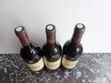 three bottles of wine sitting on top of a marble counter top