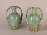 two green vases sitting next to each other on a table