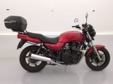 a picture of a red motorcycle parked in a white room