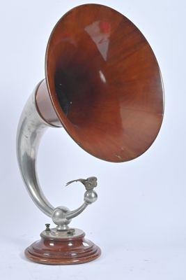 un gramophone en argent et en bois posé sur un socle en bois