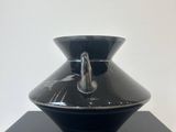 a black vase sitting on top of a black table