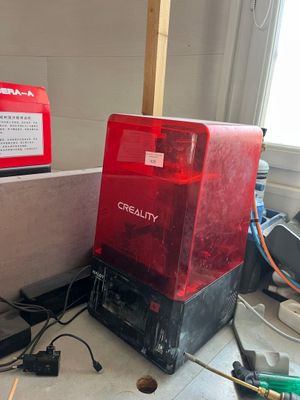 une boîte rouge posée par terre à côté d'une boîte noire