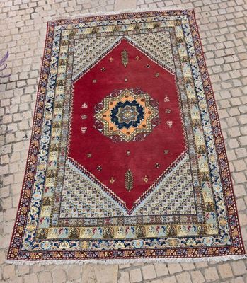 un tapis rouge et bleu posé sur un sol en briques