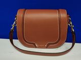 un sac à bandoulière en cuir marron posé sur une table