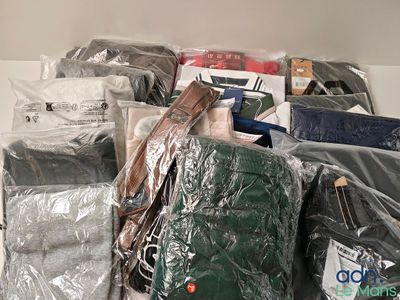 une pile de vêtements emballés dans du plastique, posée sur une étagère
