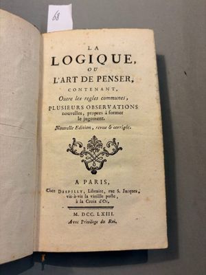un livre ouvert posé sur une table, avec une étiquette dessus
