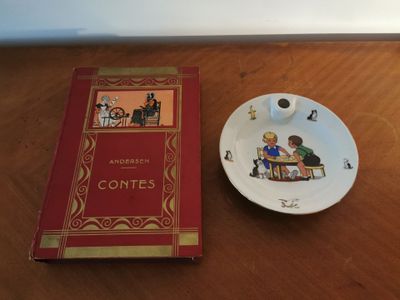 a plate with a book on it next to a cup and saucer