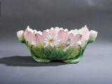 un bol rose et vert orné de fleurs blanches