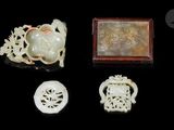 quatre pièces de jade sculpté et d'objets en jade sur un fond noir