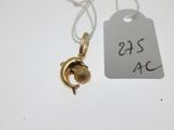 a small gold charm with a bell hanging from it ' s neck
