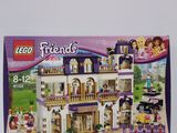 La boîte est ouverte pour montrer le contenu de la maison Lego Friends.