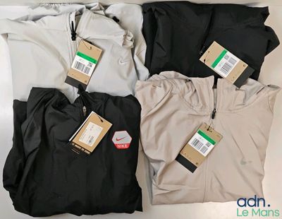 trois paires de pantalons pour homme, encore étiquetées, posées sur une table