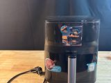 un gros plan sur une cafetière noire posée sur une table en bois