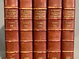 six vieux livres sont alignés sur une table