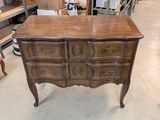 a wooden chest of drawers in the middle of a room