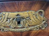 a brass plate with a bird on it on a wooden table