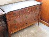 a marble top chest of drawers next to a dresser