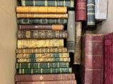an open box filled with lots of old books sitting on top of a table