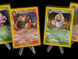 four pokemon cards are lined up in a row on a black background