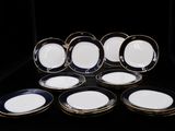 six assiettes bleues et blanches à bord doré sur fond noir