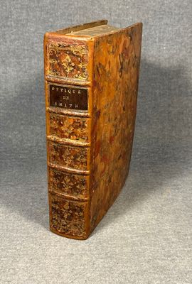 an old book sitting on top of a table next to a gray wall