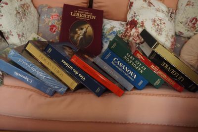 de nombreux livres posés sur un canapé rose