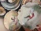 a person holding a plate with a bird painted on it