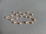un ensemble de cinq piercings de nez dorés sur un fond gris