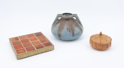 un petit vase et une petite boîte posés sur une surface blanche