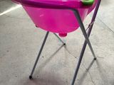 baignoire pour bébé rose avec une poignée et des pieds verts