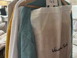 a white bag hanging on a clothes rack in a room