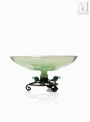 un saladier en verre vert posé sur un support métallique, sur fond blanc