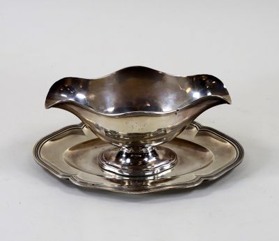 une assiette en argent avec une soucoupe posée dessus