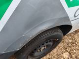 a close up of a green and white car parked on the side of the road
