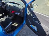 a blue car with its door open on the side of the road