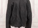 the back of a black jacket with a fur collar on a mannequin stand