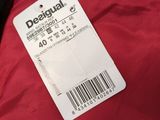 a red jacket with a tag on it sitting on a table