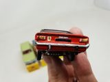 a person holding a toy car in their hand