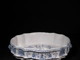 an old blue and white bowl sitting on top of a black table