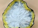 a yellow and white plate with a leaf design on it