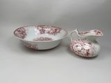 two red and white dishes and a bowl on a white surface