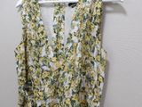 a yellow and green floral dress hanging on a hanger