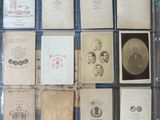several old photographs of men and women are on display in a glass case