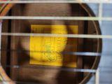 a close up of a guitar with a yellow sticker on it