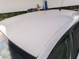 a white car parked in front of a white house