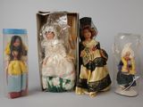 three dolls are in a box and one has a doll in a dress