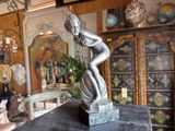 a statue of a woman that is sitting on top of a table